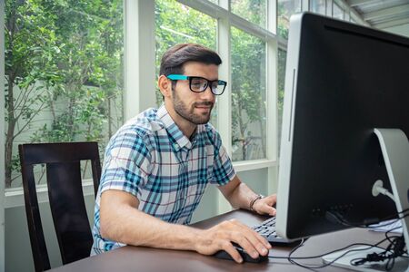 Good looking young business man working on the internet at homeの写真素材