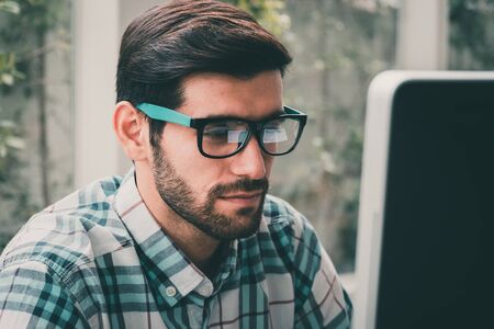 Good looking young business man working on the internet at homeの写真素材