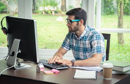 Good looking young business man working on the internet at homeの写真素材