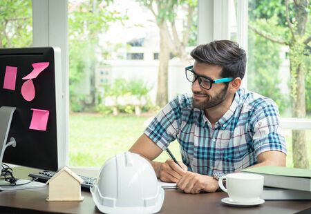 Young caucasian engineer working at his desk work station in home office.の写真素材