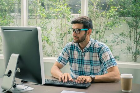 Good looking young business man working on the internet at homeの写真素材