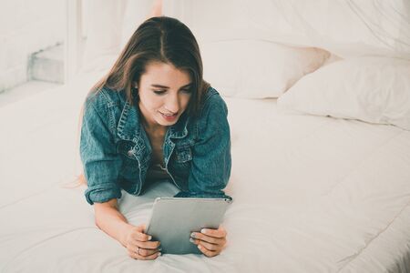 Beautiful girl surfing the internet with iPad in a relaxing time.