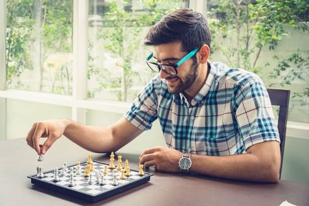 Casual businessman playing chess game with retro style photo, in business competition and planning strategies concept.の写真素材