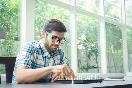 Casual businessman playing chess game with retro style photo, in business competition and planning strategies concept.の写真素材