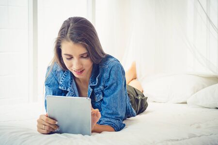 Beautiful girl surfing the internet with tablet in a relaxing time.の写真素材