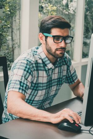 Good looking young business man working on the internet at homeの写真素材