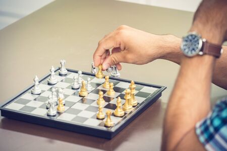 Casual businessman playing chess game with retro style photo, in business competition and planning strategies concept.の写真素材