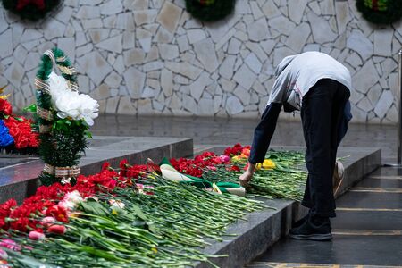 People offering (laying) the flowers on the granite in the memorial ceremeny of Russian soldiers in victory day of Soviet.の写真素材