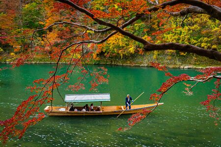 Boatman paddling the boat at Arashiyama forest view in the Autumn along Katsura river. Kyoto, Japan.の写真素材