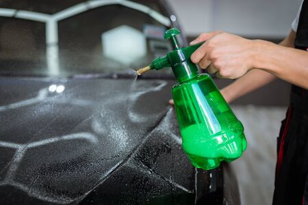 Car cleaning auto service : the man sprays water - car detailing conceptsの写真素材