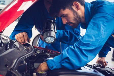 Mechanics checking and repairing the car. Car auto services concepts