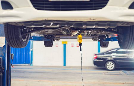 Car lifting on a hoist in the auto service company for fixing and replacing spare parts concepts
の写真素材