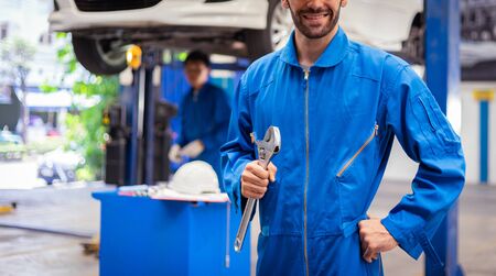 Mechanics holding wrench in the workshop garage. Auto car services conceptsの写真素材