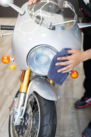 Young Asian man cleaning retro motorcycle  by microfiber cloth.の写真素材