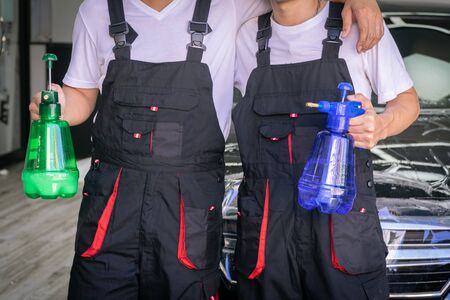 Car wash specialists standing with spray in their hands. selective focused