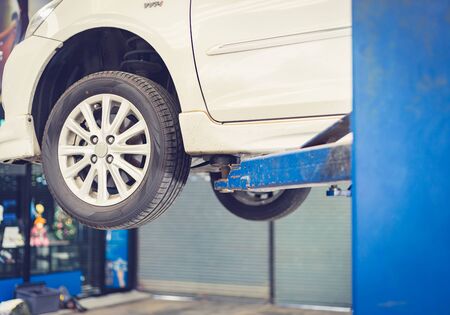 Car lifting on a hoist in the auto service company for fixing and replacing spare parts concepts
の写真素材