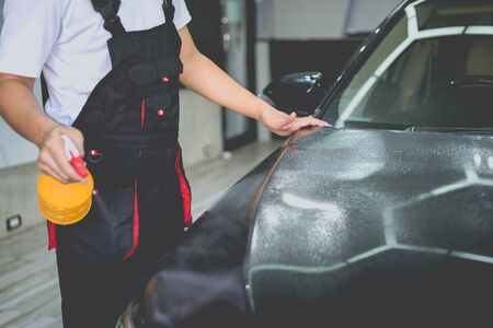 Car cleaning auto service : the man sprays water - car detailing conceptsの写真素材