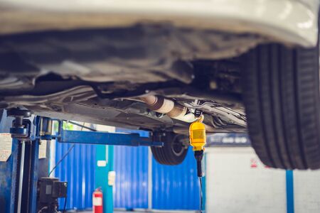 Car lifting on a hoist in the auto service company for fixing and replacing spare parts concepts