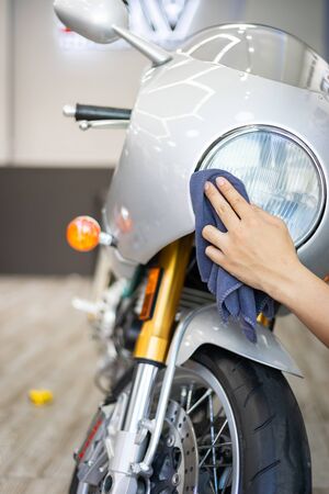 Young Asian man cleaning retro motorcycle  by microfiber cloth.の写真素材
