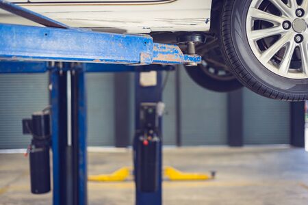 Car lifting on a hoist in the auto service company for fixing and replacing spare parts concepts
の写真素材