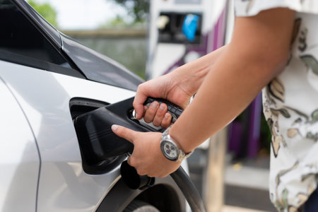 Electric car charging at the station. Sustainability and renewable energy concept. Electric vehicle (EV) fuel advance, save the earth conception.の写真素材