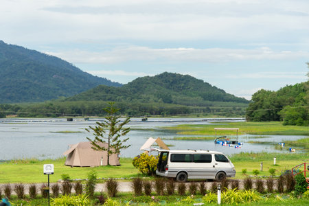 Camping picnic green tent campground in outdoor park lake. Camper while campsite in mountain and lake nature background at summer trip camp. Adventure Travel and Vacation conceptの写真素材