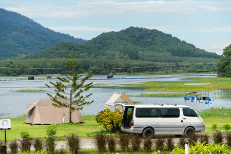Camping picnic green tent campground in outdoor park lake. Camper while campsite in mountain and lake nature background at summer trip camp. Adventure Travel and Vacation conceptの写真素材