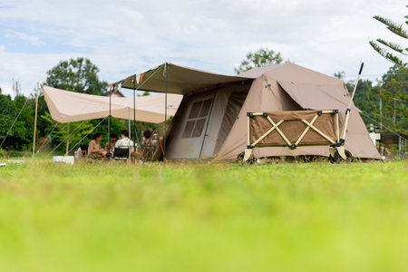 Camping picnic green tent campground in outdoor park lake. Camper while campsite in mountain and lake nature background at summer trip camp. Adventure Travel and Vacation conceptの写真素材