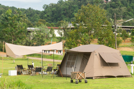 Camping picnic green tent campground in outdoor park lake. Camper while campsite in mountain and lake nature background at summer trip camp. Adventure Travel and Vacation conceptの写真素材