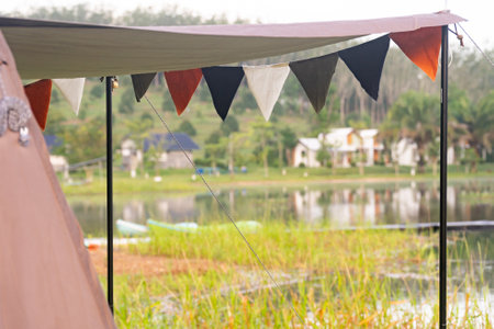 Camping picnic green tent campground in outdoor park lake. Camper while campsite in mountain and lake nature background at summer trip camp. Adventure Travel and Vacation conceptの写真素材