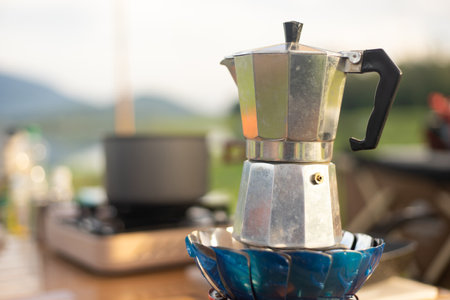 Food lover at Camping! Dripping coffee during camping at natural lake and mountain view background. Recreation and journey outdoor activity lifestyle.の写真素材