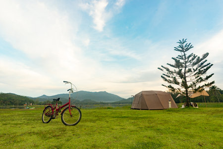 Camping picnic green tent campground in outdoor park lake. Camper while campsite in mountain and lake nature background at summer trip camp. Adventure Travel and Vacation conceptの写真素材