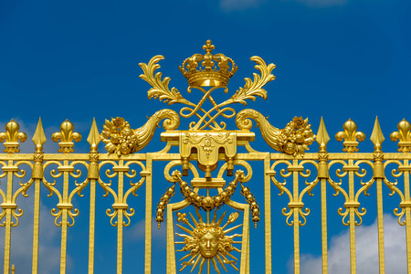 Versailles, France - May 19, 2016: Golden gate entrance of Versailles palace in sunny day with blue...