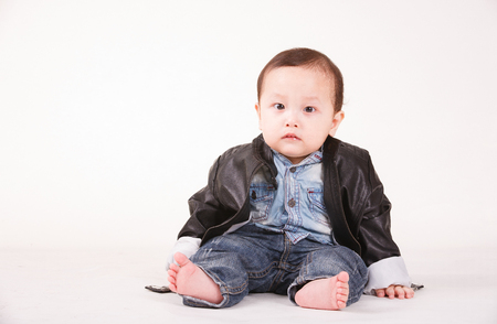 portrait of baby boy in leather jacket, white backgroundの写真素材