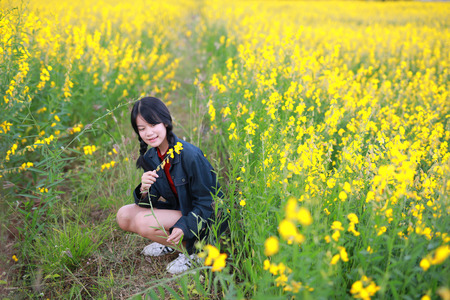 Portrait of the beautiful girl with yellow flowers,sunny summer day in field of yellow flowersの写真素材