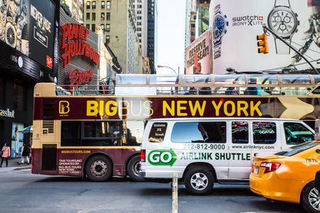 New York City, New York, USA - March 23, 2015: Street scene with taxicab, van and tourist bus along...