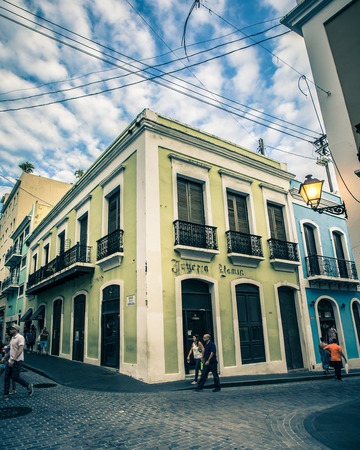 Old San Juan, Puerto Rico - March 29, 2015:  Cobblestone street scene from Old San Juan, Puerto Rico with colorful buildings and people walking.のeditorial素材
