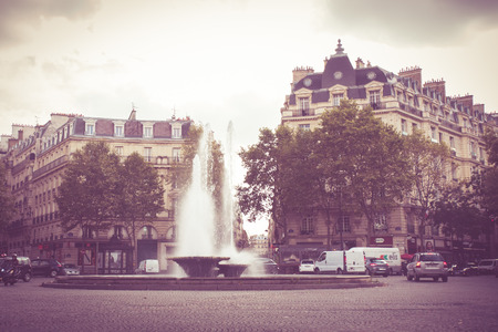 Paris, France - October 9, 2014: Vintage style image of Paris France traffic circle with fountain and cars.のeditorial素材