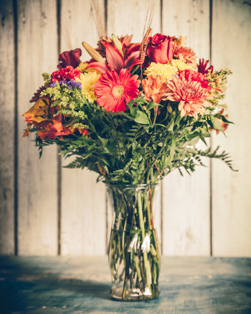 Autumn flower bouquet in vase with vintage tone filter effectの写真素材