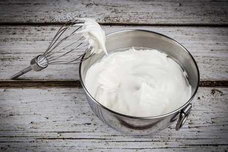 Whipped cream in bowl with and whiskの写真素材