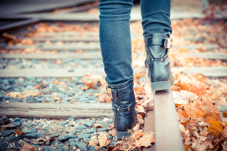 Black leather boots along old railroad tracks. Vintage toned image.の写真素材