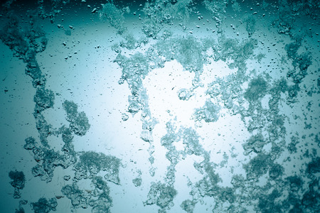 toned winter window with snow and water droplets