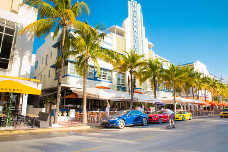 Miami Beach, Florida, USA - April 24, 2016: View along the famous vacation and tourist location on Ocean Drive in the Art Deco district of South Beach, Miami on a sunny day with cars,  palm trees and people visible.のeditorial素材