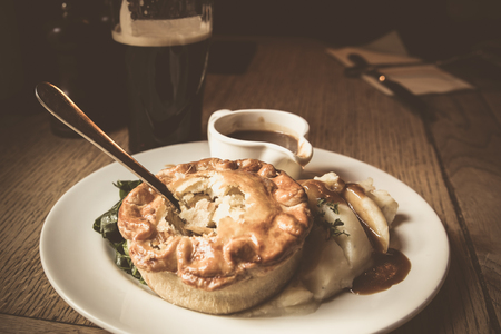 Traditional savory chicken pot pie served in pub with beer in the backgroundの写真素材