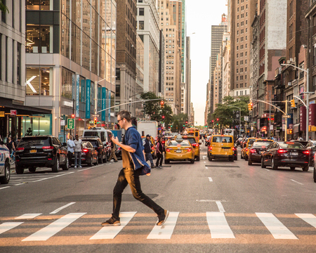 NEW YORK CITY - JUNE 16, 2018:  View of midtown Manhattan at intersection with cars, taxi cabs and people on a typical day.のeditorial素材