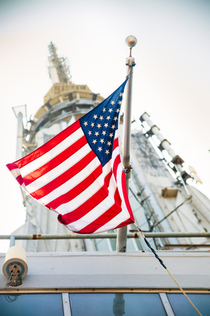 NEW YORK CITY - JULY 16, 2018: American Flag waves in the breeze on top of the Empire State Building in Manhattan.のeditorial素材