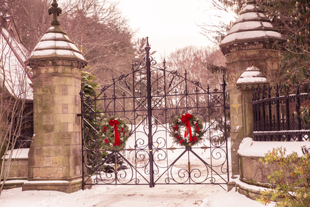 Old vintage cemetery gates architecture with snow and Christmas wreath from Forest Hills Cemetery in Boston areaの写真素材