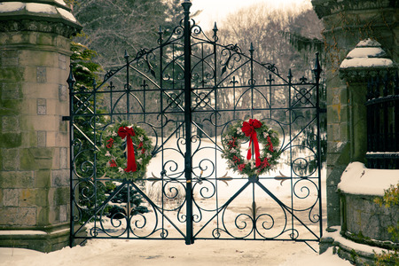 Old vintage cemetery gates architecture with snow and Christmas wreath from Forest Hills Cemetery in...