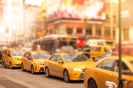 Defocused blur of a line of New York City yellow taxi cabs at rush hour in midtown Manhattan with...