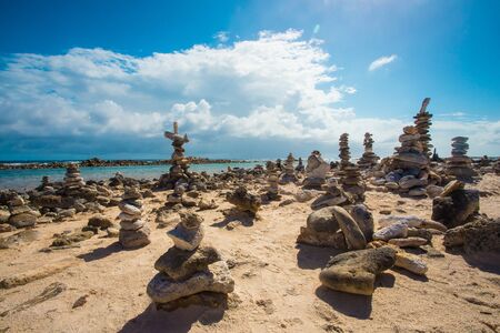 Stacked rocks balance on rocky beach in Arubaの写真素材